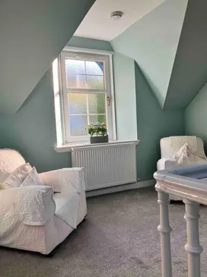 a attic room with a bed and a window at The Villas in Helensburgh