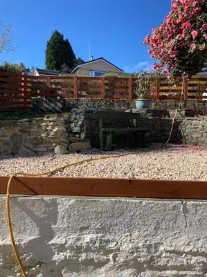 a wooden fence with a bench in a yard at The Villas in Helensburgh