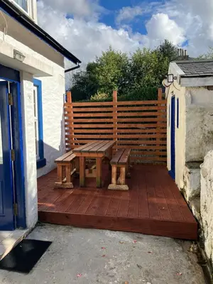 a wooden bench sitting on a wooden deck at The Villas in Helensburgh