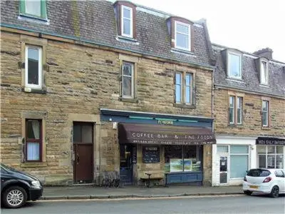 a brick building with a car parked in front of it at Snug - Fountain Bank Apartment in Helensburgh