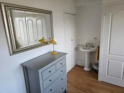 a bathroom with a sink and a mirror on the wall at Snug - Colquhoun Square Apartment in Helensburgh