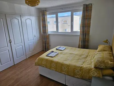 a bedroom with a bed and a window at Snug - Colquhoun Square Apartment in Helensburgh