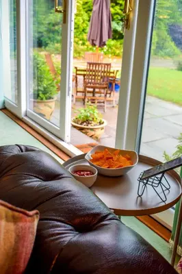 a table with a bowl of food on a porch at Heatherbank Cottage in Onich