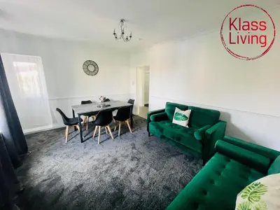 a living room with a green couch and a table at Mitchell Apartment by Klass Living Coatbridge in Coatbridge
