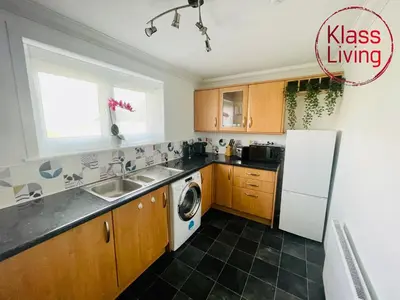 a kitchen with a sink and a refrigerator at Mitchell Apartment by Klass Living Coatbridge in Coatbridge