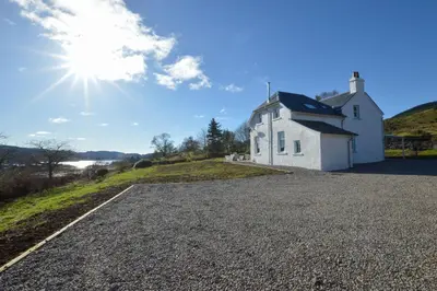 a white house on the side of a road at Achalic Farm House in Lerags