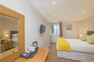 a hotel room with a bed and a mirror at Falls of Lora Hotel in Oban