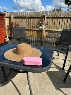 a straw hat and a pink box on a table at Loch Lomond Apartment in Alexandria