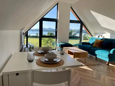 a living room with a table and a blue couch at Còsagach Flat near Oban in Barcaldine