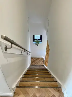 a staircase in a house with white walls and wooden floors at Còsagach Flat near Oban in Barcaldine