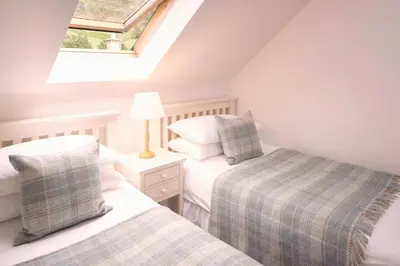 a attic bedroom with two beds and a skylight at Eastside Steading - Family barn in the Pentland Hills, Edinburgh in Penicuik