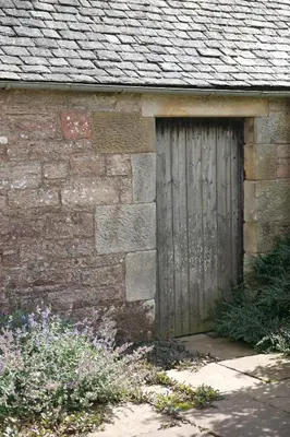 a wooden door on the side of a brick building at Eastside Byre - Family cottage in the Pentland Hills near Edinburgh in Penicuik