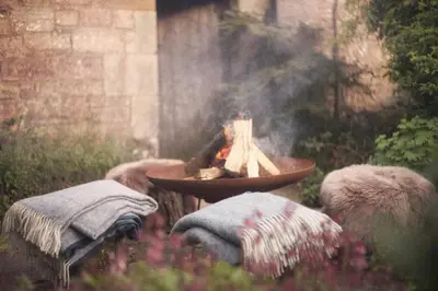 a fire pit in a garden with a bowl of smoke at Eastside Byre - Family cottage in the Pentland Hills near Edinburgh in Penicuik