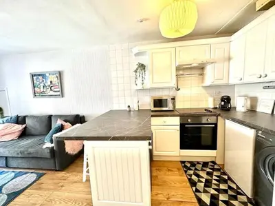a living room with a couch and a kitchen at City Centre Hidden Hideout for 2 in Edinburgh