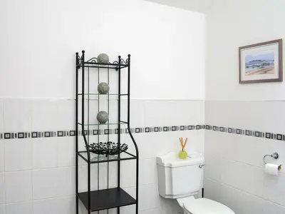 a bathroom with a toilet and a black shelf at Sorbie Villa in Stevenston