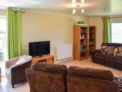 a living room with a couch and a tv at Little Glengyre Farm in Kirkcolm