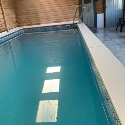 a swimming pool with blue water in a building at Jane Welsh Cottage in Thornhill