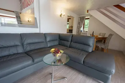 a blue couch in a living room with a glass table at Jane Welsh Cottage in Thornhill