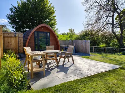 a patio with a table and chairs and a gazebo at Devonknowes lodges in Tillicoultry