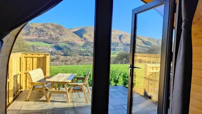 a patio with a table and chairs and a view of mountains at Devonknowes lodges in Tillicoultry