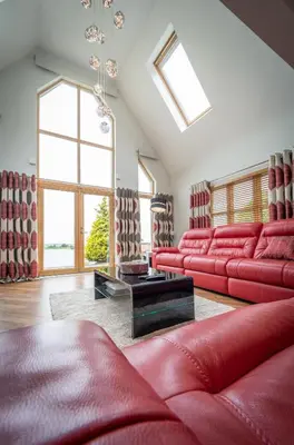 a living room with red furniture and a large window at The Hoose at The Vu in Bathgate