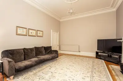 a living room with a couch and a flat screen tv at Burnock Lodge with Hot Tub in Ayr