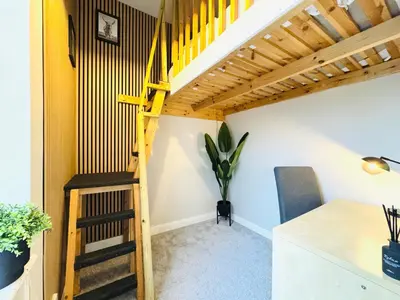 a loft apartment with a staircase and a plant at City Centre Escape with Private Garden in Edinburgh