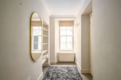 a hallway with a mirror and a rug at New Town Garden Retreat by Calton Living in Edinburgh