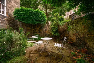 a patio with a table and chairs in a garden at New Town Garden Retreat by Calton Living in Edinburgh