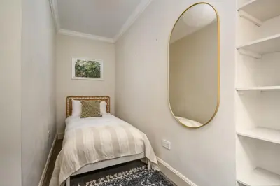 a small bedroom with a mirror and a bed at New Town Garden Retreat by Calton Living in Edinburgh