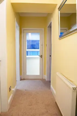 an empty hallway with a door and a window at West Apartment in Coatbridge