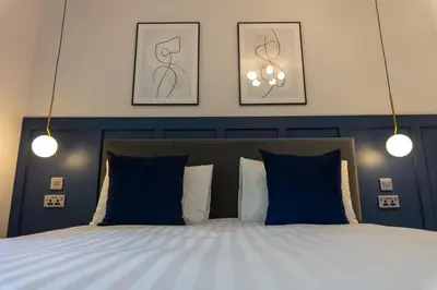 a bedroom with a bed with blue and white pillows at Oban Apartments in Oban