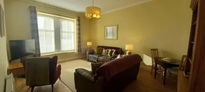 a living room with a couch and chairs and a table at Stunning Village Centre Holiday Home in Callander