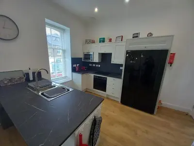 a kitchen with a black refrigerator and a counter top at Stunning Village Centre Holiday Home in Callander