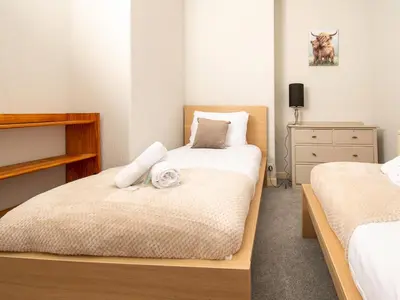 a small bedroom with two beds and a dresser at Private Entrance GF 2 bed flat near Renfrew Centre - Pass the Keys in Renfrew