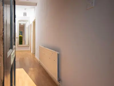 a hallway with a radiator on a white wall at Private Entrance GF 2 bed flat near Renfrew Centre - Pass the Keys in Renfrew