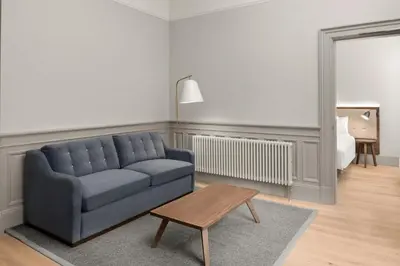 a living room with a blue couch and a table at AC Hotel by Marriott Glasgow in Glasgow