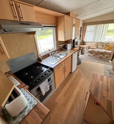 a kitchen with a stove and a sink in a caravan at 4-Bedroom Cosalt Located in Uddingston, Glasgow at Maryville Caravan Site in Uddingston