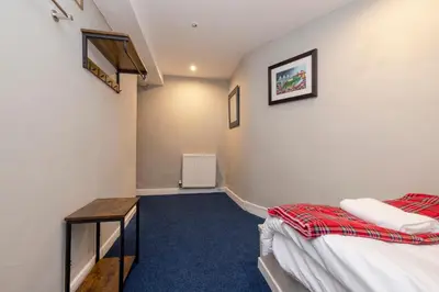 a room with two beds and a table in it at New Town Rooms in Edinburgh