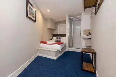 a small room with a bed and a walk in shower at New Town Rooms in Edinburgh