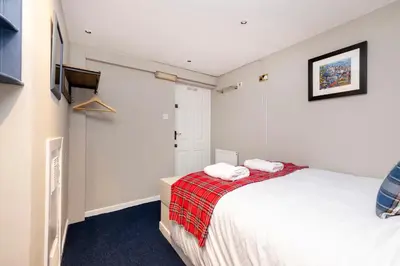 a bedroom with a bed with two towels on it at New Town Rooms in Edinburgh