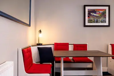 a dining room with red chairs and a wooden table at New Town Rooms in Edinburgh