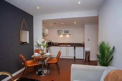 a living room with a table and chairs and a kitchen at 1 Bedroom Apartment in Very Central Location in Glasgow