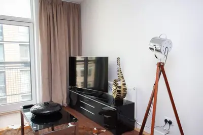 a living room with a television and a camera at Fantastic City Centre Flat in Glasgow