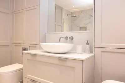 a white bathroom with a sink and a toilet at Deluxe 3-bedroom Apartment on Princes Street overlooking Edinburgh Castle in Edinburgh