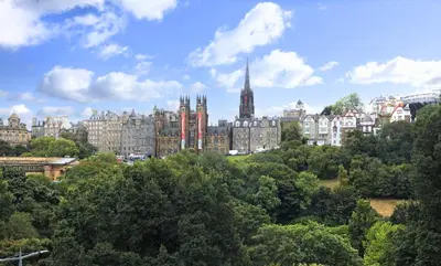 a cityscape of a city with buildings and trees at Deluxe 3-bedroom Apartment on Princes Street overlooking Edinburgh Castle in Edinburgh