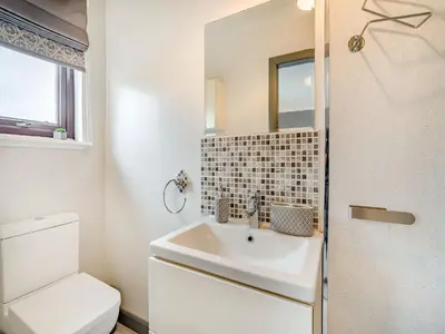 a white bathroom with a sink and a toilet at Highview in Brodick