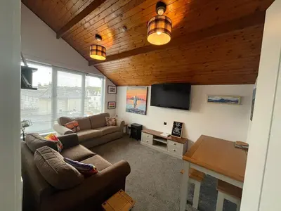 a living room with a couch and a tv at The Mail Barn Studio in Lamlash