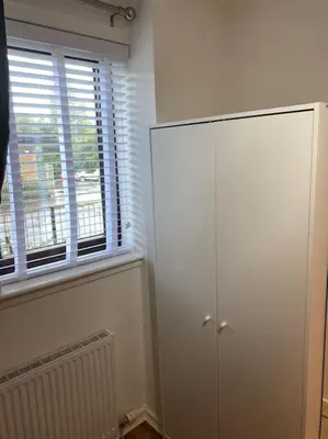 a white cabinet in a room with a window at Perfectly situated luxury 2 bedroom apartment in Glasgow