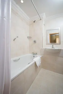 a white bathroom with a tub and a sink at Loch Awe Hotel in Dalmally